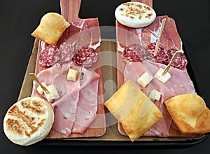 Traditional bolognese tray with typical products: tigelle, crescentine gnocco fritto, mortadella, salami and ham, Parmigiano Reg photo