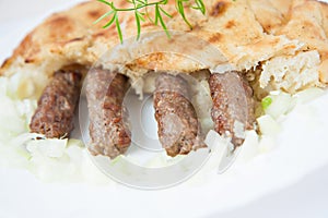 Traditional bosnian food cevapi with flat bread and onion