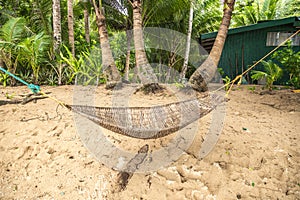 Traditional braided hammock in the shade with tropical island in the background