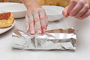 Traditional Brazilian dessert known as BOLO GELADO in Portuguese - Making step by step: Woman hand wrapping sliced cake