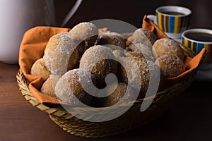 Traditional Brazilian mini fried cakes called bolinho de chuva in a basket in wood breakfast table background close photo