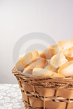 Traditional Brazilian starch biscuit called biscoito de polvilho in a basket on a table covered with white tablecloth, selective photo