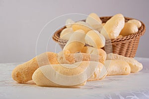 Traditional Brazilian starch biscuit called biscoito de polvilho in a basket on a table covered with white tablecloth, selective photo