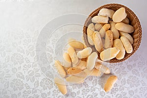Traditional Brazilian starch biscuit called biscoito de polvilho in a basket on a table covered with white tablecloth, Top view photo