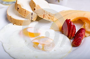 Traditional breakfast of egg, chopped fruit and bread