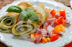 A traditional Breakfast. Omelette with spinach and a fresh tomato salad, red onion and Basil. Roll scrambled eggs