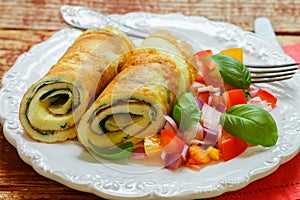 A traditional Breakfast. Omelette with spinach and a fresh tomato salad, red onion and Basil. Roll scrambled eggs