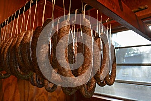 Traditional breakfast sausage hanging in a smokehouse. Family gathering for a food preservation.