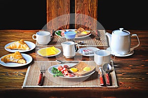 Traditional breakfast set for two persons on the wooden table.