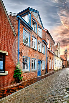 Traditional Brickhouse with blue and white windows in a norrow street in Leer, East Frisia, Germany