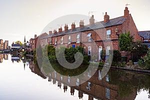 Traditional British brick terraced houses along a canal at sunset