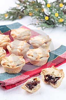 Traditional British Christmas mince pies with fruit filling, on festive cloth, vertical