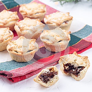 Traditional British Christmas mince pies with fruit filling, on festive cloth, square format