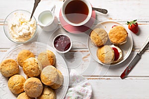 Traditional british scones with clotted cream and strawberry jam with a cup of tea photo