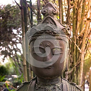 Traditional buddhist statue of female in bamboo garden