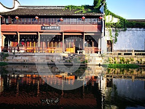 Traditional buildings reflecting on peaceful river