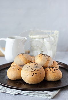 traditional bun with black sesame seeds on a metal tray