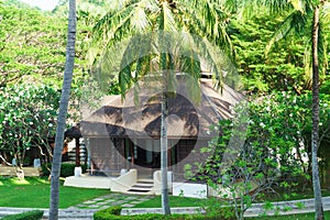 Traditional Bungalow in the Asian garden. Exotic plants and flowers, beautiful landscape.