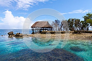 Traditional bungalow of native aborigines Micronesian people. Reef coral island motu. Blue azure turquoise lagoon. Pohnpei island.