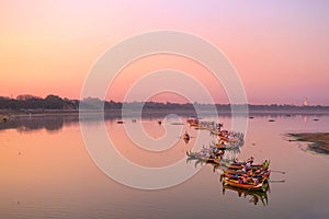 Traditional burmese boats on Taungthaman Lake at sunset, in Amarapura, Mandalay Myanmar