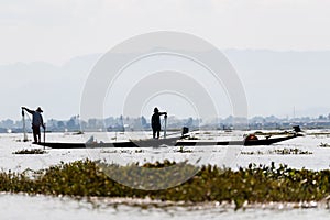 Traditional Burmese fisherman at Inle lake, Myanmar famous for their distinctive one legged rowing style