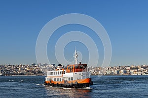 A traditional cacilheiro ferry boat crossing the Tagus River Rio Tejo with the city of Lisbon skyline on the background