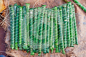 Traditional cameroonian bÃÂ¢ton de manioc made of manioca wrapped in plantain leaves on ground in african village photo