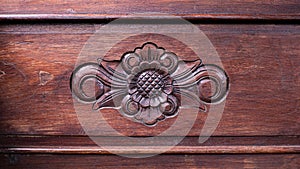Traditional carved wooden pattern in the center of brown old wood