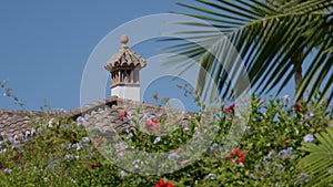 Traditional Chimney and Roof Tiles Framed by Colorful Garden Blooms