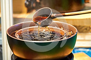 Traditional Chinese copper pot is cooking Pu\'er tea, making tea around the stove