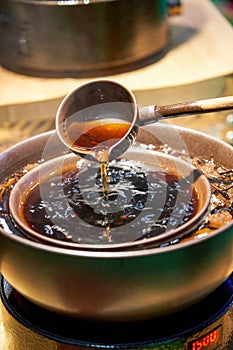 Traditional Chinese copper pot is cooking Pu\'er tea, making tea around the stove