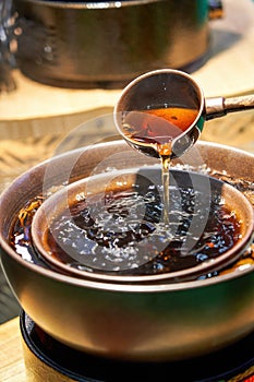 Traditional Chinese copper pot is cooking Pu\'er tea, making tea around the stove