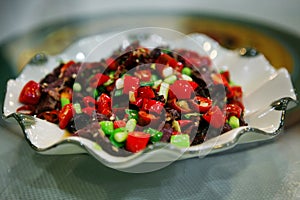 Traditional Chinese dish with slices of roast beef and red hot pepper, served on a white plate. Beijing, China.