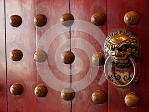 Traditional Chinese doors with brass handles symbolic of lion's heads