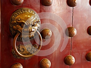 Traditional Chinese doors with brass handles symbolic of lion's heads