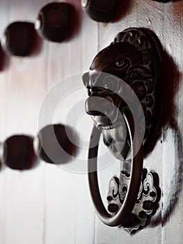 Traditional Chinese doors with brass handles symbolic of lion's heads