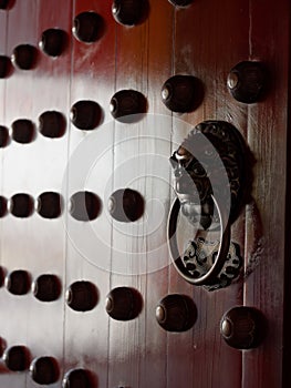 Traditional Chinese doors with brass handles symbolic of lion's heads