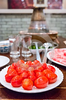 A traditional Chinese hotpot with meat and condiments.