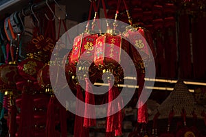 Traditional Chinese red paper lanterns with golden hieroglyph wishes of luck in Chinese language. Closeup of hanging lanterns