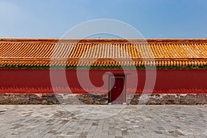 Traditional Chinese red wall and yellow roof tiles with closed door, in Forbidden City, in Beijing, China