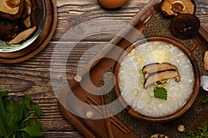 Traditional Chinese rice porridge with shiitake mushroom, soft boiled egg, slice ginger and slice scallion topping on
