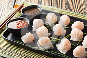 Traditional chinese steamed dumplings Dim Sums Har gow with shrimp served with sauce closeup. Horizontal