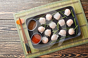 Traditional chinese steamed dumplings Dim Sums Har gow with shrimp served with sauce closeup. Horizontal top view