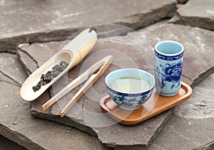 Traditional chinese tea ceremony accessories (tea cups and bamboo scoop of green tea), selective focus