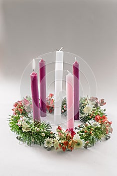 Traditional christian religious advent wreath with 5 candles, one candle burning