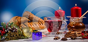 Traditional Christmas apple punch with cinnamon and honey on a table of candles background