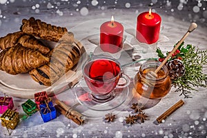 Traditional Christmas apple punch with cinnamon and honey on a table of candles background