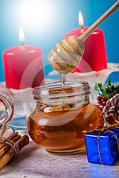 Traditional Christmas apple punch with cinnamon and honey on a table of candles background