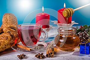 Traditional Christmas apple punch with cinnamon and honey on a table of candles background