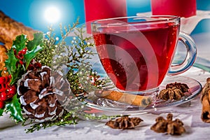 Traditional Christmas apple punch with cinnamon and honey on a table of candles background